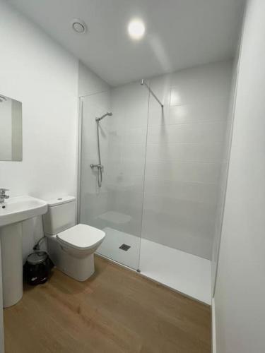 a white bathroom with a shower and a toilet at Nidito Sandua in Pamplona
