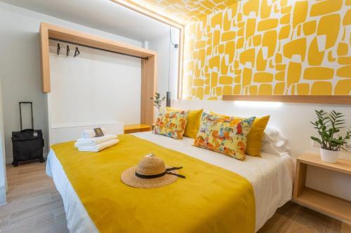 un dormitorio con una cama amarilla con sombrero en Eleven Boutique Apartments, en Las Palmas de Gran Canaria