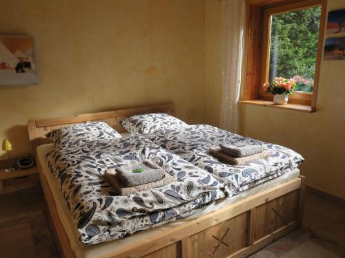 - un lit avec une couette en noir et blanc et une fenêtre dans l'établissement Ferienhaus-Sonne-Harz-Sterne, à Hohegeiss