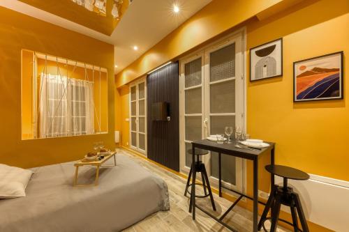 a yellow room with a bed and a table and chairs at Deluxe SPA suite caramel sweetness in Melun