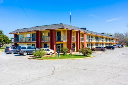 un gran edificio con coches estacionados en un estacionamiento en Castle Inn & Suites By OYO Chickasha, en Chickasha