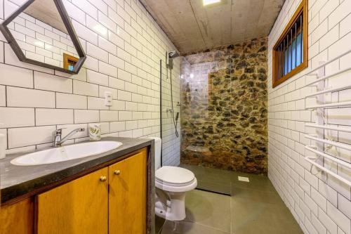 ein Badezimmer mit Toilette und Waschbecken in der Unterkunft Casa de Piedra - Pousada NaCarapina in São Francisco de Paula