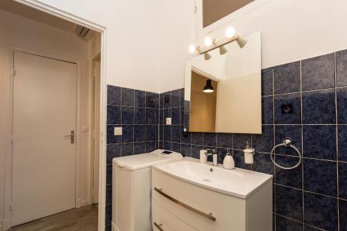 ein Bad mit einem Waschbecken und einem Spiegel in der Unterkunft Elegant 2 rooms in the heart of Cannes in Cannes