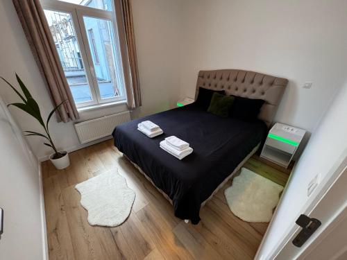 ein kleines Schlafzimmer mit einem Bett und einem Fenster in der Unterkunft Cozy South-Up in Brüssel