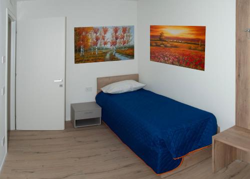 a bedroom with a bed and two paintings on the wall at BELLAViTA LAKE GARDA Apartments in Arco