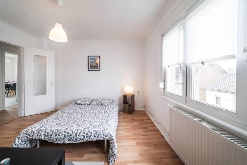 une chambre avec un lit et une grande fenêtre dans l'établissement Mondelange - à 2 pas d'Amnéville, à Mondelange