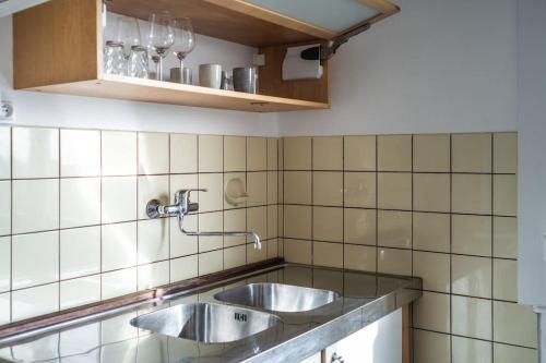 une cuisine avec deux éviers dans un mur carrelé dans l'établissement Mondelange - à 2 pas d'Amnéville, à Mondelange