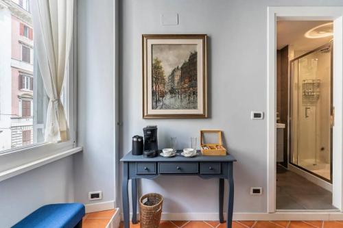 a blue table in a room with a picture on the wall at Fori Imperiali Luxe Mansion in Rome