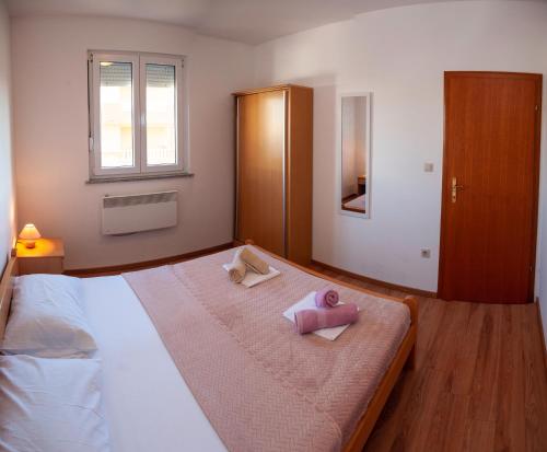 a bedroom with a bed with two towels on it at Apartment BOSS in Novalja