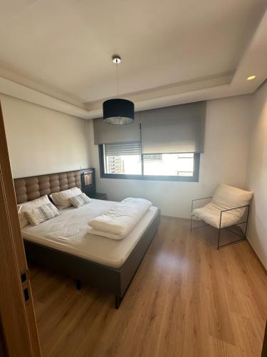 Un pat sau paturi într-o cameră la Appartement haut standing en Résidence