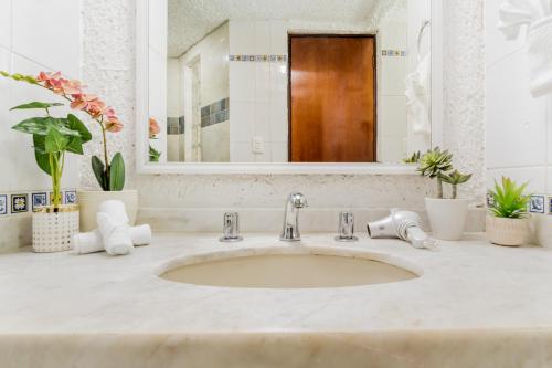 a bathroom with a sink and a mirror at Amazing Villas at Las Cupulas in Cancún