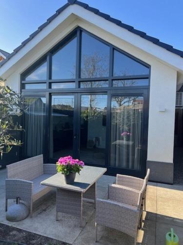 a table and two chairs and a table with flowers on it at Cozy & Modern Tiny House in Velserbroek 