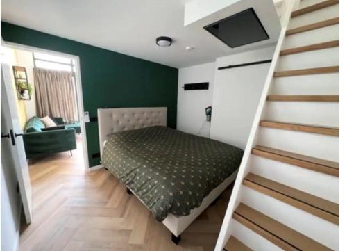 a bedroom with a bed next to a staircase at Cozy & Modern Tiny House in Velserbroek 