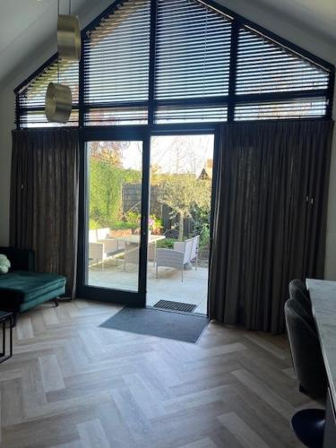 a living room with a large glass door to a patio at Cozy & Modern Tiny House in Velserbroek 