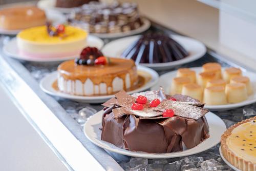 a bunch of cakes and pastries on plates on a counter at Beach Park Resort - Suites in Aquiraz