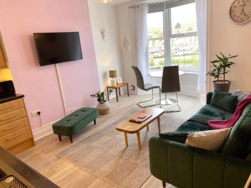 a living room with a couch and a table at Tideway Apartment with Private Parking Space in Whitby