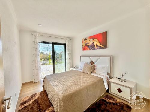 une chambre avec un lit et une grande fenêtre dans l'établissement Pavilhão 2 - Quinta da Prelada Simão, à Celorico de Basto