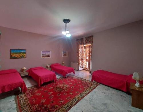 sala de estar con 2 camas y alfombra roja en Torre Adelasia, en Aidone