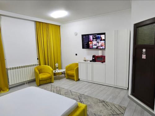 a hospital room with a bed and two yellow chairs at Garsoniera Craiova Centru Vechi in Craiova