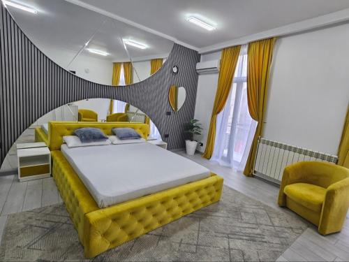 a bedroom with a yellow bed and a yellow chair at Garsoniera Craiova Centru Vechi in Craiova