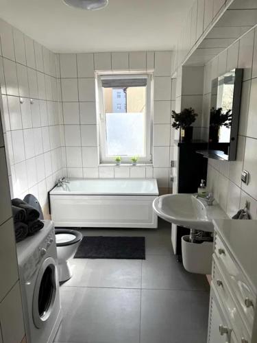 a bathroom with a tub and a toilet and a sink at Apartament przy Browarze in Olsztyn