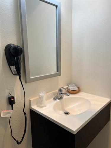 a bathroom sink with a phone hanging on the wall at Port Townsend Inn in Port Townsend