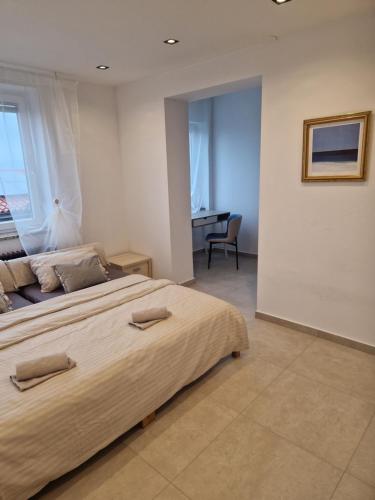a bedroom with a large bed and a desk at apartmans robo in Koper