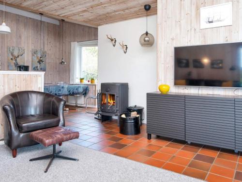 a living room with a chair and a fireplace at 8 person holiday home in Ebeltoft in Ebeltoft
