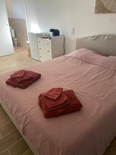 two towels are sitting on a bed in a bedroom at Cocon à quelques minutes des plages du Roussillon in Saint-Nazaire