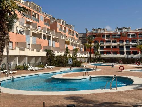 a large swimming pool in front of a large apartment building at Vive Vera Rentals - Puerto Rey Apto Marina 2Habs in Los Amarguillos