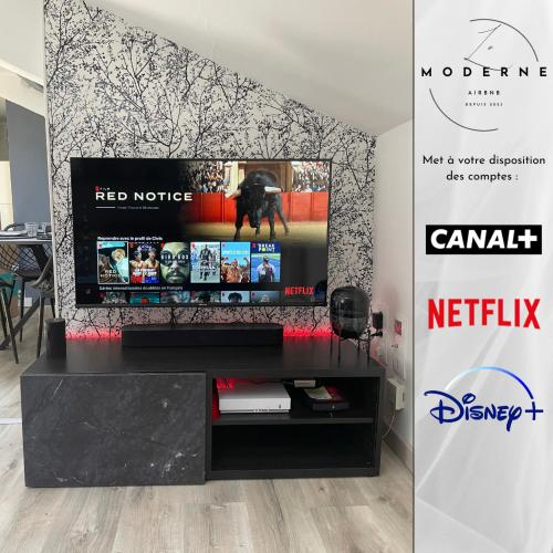 - une télévision à écran plat installée au-dessus d'un centre de divertissement dans l'établissement Le Moderne, à La Chapelle-Saint-Luc