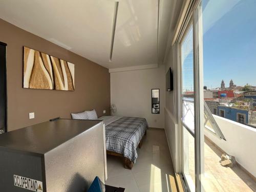 1 dormitorio con cama y ventana grande en ESPACiOS RAYON en Morelia