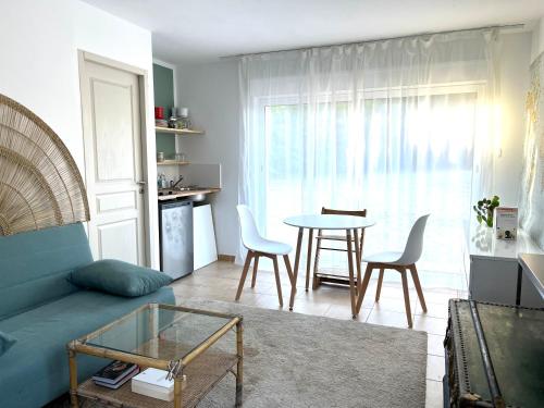 un salon avec un canapé, une table et des chaises dans l'établissement Appartement dans villa, parking, accès piscine, au Plan-de-la-Tour