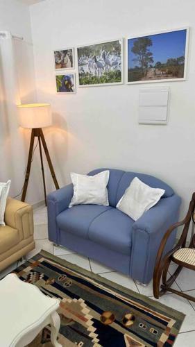 a living room with a blue couch and a chair at Casa Sossego com Piscina em Chapada dos Guimarães in Chapada dos Guimarães
