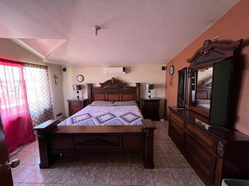 a bedroom with a large wooden bed and a mirror at GR20acd Jany in Cuauhtémoc