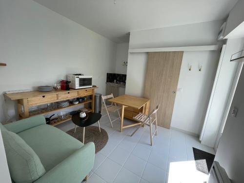 un salon avec un canapé et une table dans l'établissement Maison indépendante au calme - 1ch, à Saint-Herblain