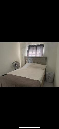 a bedroom with a bed with a window and a bedskirtspectspectspectspects at Casa de Esquina En La Chorrera in La Chorrera