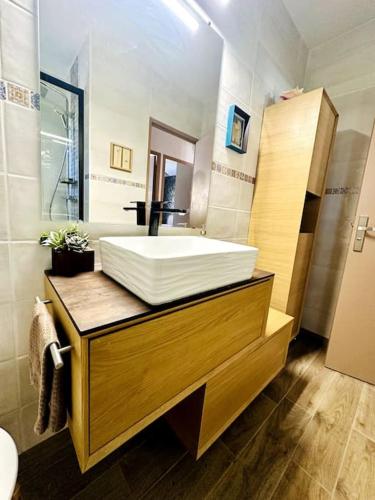 une salle de bain avec un lavabo blanc et un miroir dans l'établissement Villa Les Acacias Piscine et Clim, à Saint-Maximin-la-Sainte-Baume