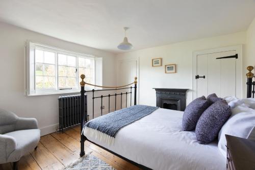 1 dormitorio con 1 cama, 1 silla y chimenea en Luxury Home, 20 Mins From Goodwood Pet Friendly!, en Stoughton