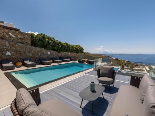 a villa with a swimming pool and a patio at Gorgeous Mykonos Villa | 4 Bedrooms | Villa Atalanta | Private Pool & Panoramic Sea Views | BBQ | Faros in Fanari