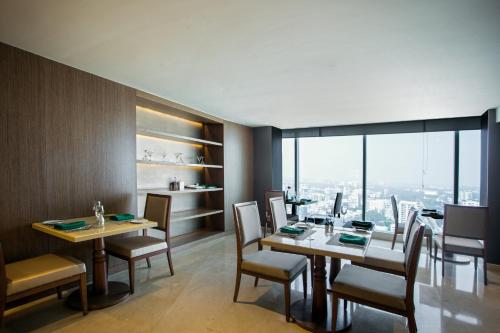 a dining room with tables and chairs and a large window at Crowne Plaza Dhaka Gulshan by IHG in Dhaka