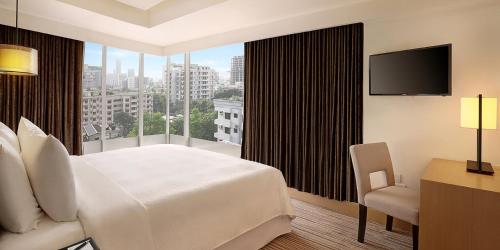 a hotel room with a bed and a large window at Crowne Plaza Dhaka Gulshan by IHG in Dhaka