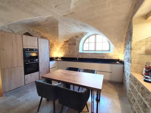 a kitchen with a table and chairs in a room at Grand appartement face au Duché d'Uzès in Uzès