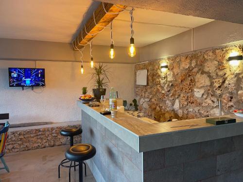 a bar in a restaurant with a stone wall at APARTMENTS Ana by the SEA in Lumbarda