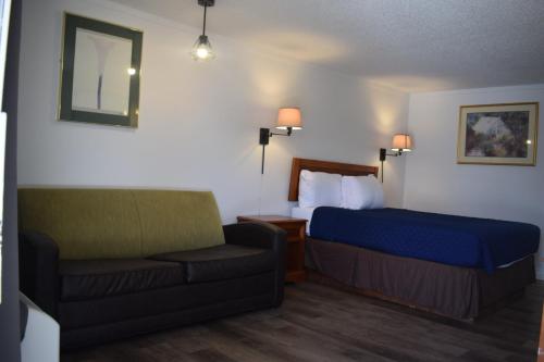 een hotelkamer met een bed en een bank bij Knights Inn Farmington Hills in Farmington Hills