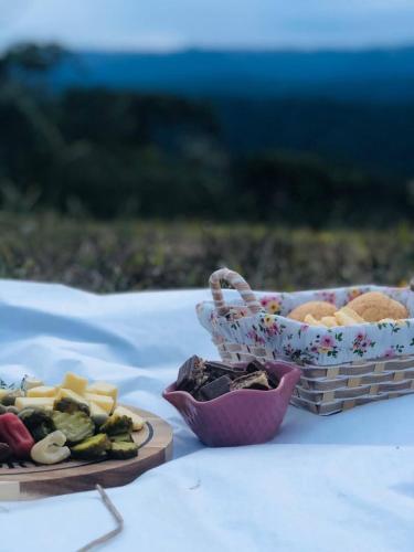 a table with two plates of food and a basket of food at Refúgio da Montanha in Urubici