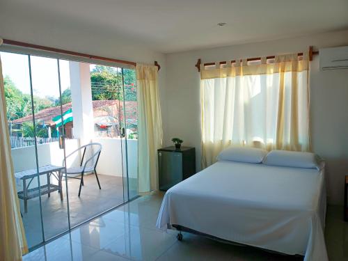 a bedroom with a white bed and a balcony at HOSTAL AMBORO in Buena Vista