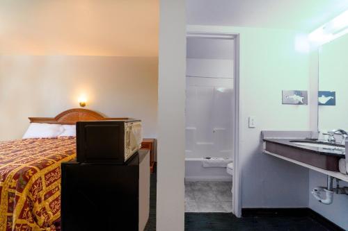 ein Hotelzimmer mit einem Bett und einem Bad in der Unterkunft Castle Inn & Suites By OYO Chickasha in Chickasha