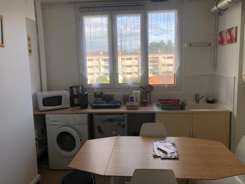une cuisine avec une table et une machine à laver dans l'établissement appartement entier 2 chambres, à Beauvais