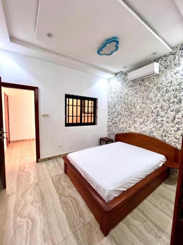 1 dormitorio con cama y pared de ladrillo en Havre de paix, en Cotonou